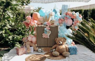 Mesa de dulces con globos para revelación de bebé